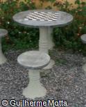 Mesa e assentos redondos de concreto com tabuleiro de xadrez